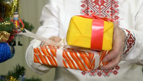 Cute-old-man-stands-near-the-Christmas-tree-with-presents