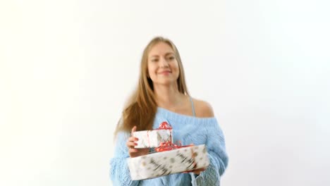 Linda-rubia-bailando-con-regalos-en-un-fondo-blanco