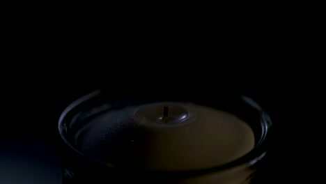 Slow-motion-macro-footage-of-a-white-candle-on-a-dark-background