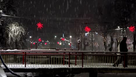 Urban-christmass-scene-of-people-walking-over-bridge-at-night-snow-blizzard