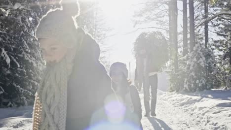 Familia-divirtiéndose-en-el-bosque-de-invierno