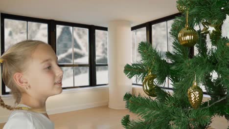 Excited-young-white-girl-decorating-christmas-tree-and-with-happy-looking-to-fir-tree.-Preparing-for-Merry-Christmas-celebrate-Holiday.-Living-room-window-snowstorm-snowfall.-Snowing-winter-weather.