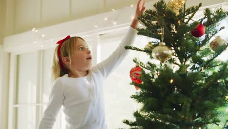 Junges-Mädchen-dekorieren-Weihnachtsbaum