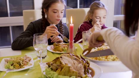 Woman-cuts-fried-chicken-at-the-festive-table