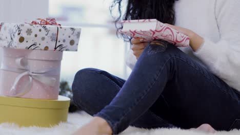 Young-girl-sits-on-floor-near-christmas-gifts-and-read-the-book