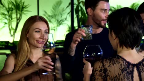 Group-of-young-people-enjoying-drinking-together-at-the-bar-in-the-evening