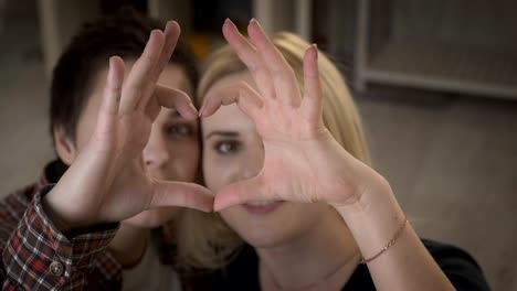 Two-young-cute-lesbian-girls-cuddle-up-and-show-the-sign-of-the-heart,-the-sign-of-love-60-fps