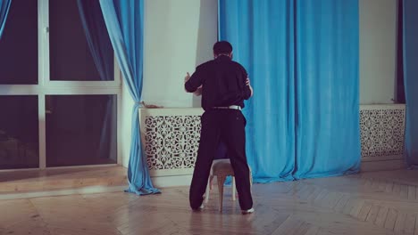 Professional-couple-dancing-tango-in-the-studio.-Young-girl-in-black-dress-and-man-dancing-latin