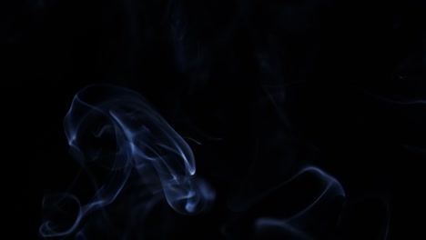 smoke-slowly-floating-through-space-against-black-background.