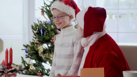 Niño-da-Santa-Claus-un-regalo-mientras-que-él-está-leyendo-la-carta-del-deseo