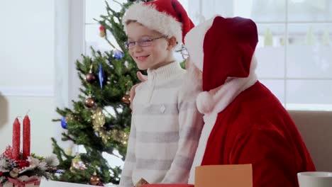 Little-boy-give-Santa-Claus-a-present-while-he's-reading-the-wish-letter