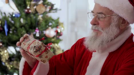 Santa-Claus-schenken-Sie-das-Geschenk-vor-der-Kamera
