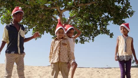 Niños-celebrando-la-Navidad-jugando-y-saltando-en-un-desierto