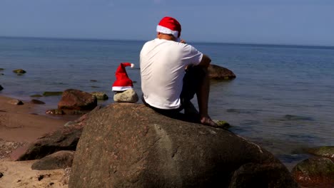 Man-with-Santa-Claus-hat-relaxing-near-the-sea