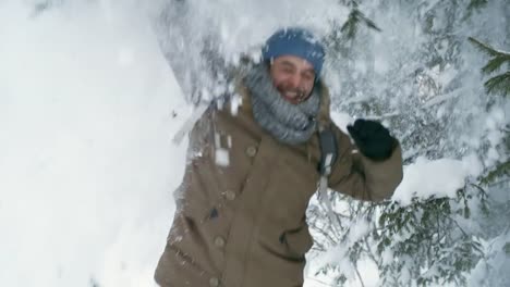 Carefree-Man-Enjoying-Snowfall-From-Tree