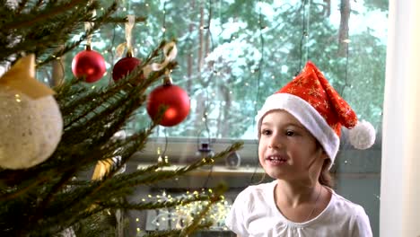 Little-cute-girl-with-her-mom-decorate-the-Christmas-tree