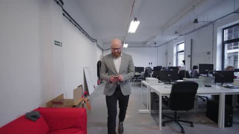 Man-entering-office-and-using-cell-phone