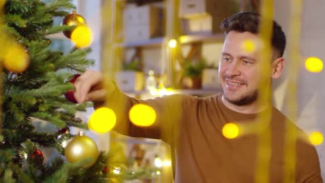 Caucasian-Man-Smiling-and-Decorating-Christmas-Tree