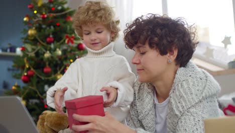 Entzückende-kleine-Junge-öffnen-Weihnachtsgeschenk