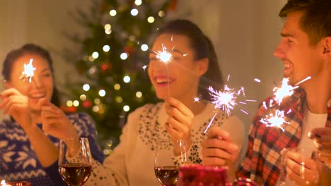 Glückliche-Freunde-mit-Wunderkerzen,-die-Weihnachts-Dinner-zu-Hause