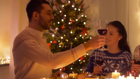 amigos-felices-bebiendo-vino-tinto-en-Navidad