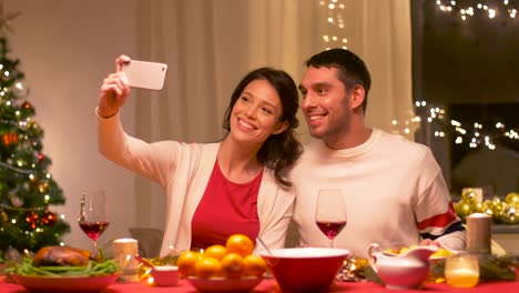 couple-taking-selfie-at-home-christmas-dinner