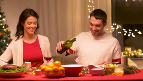 glückliches-Paar-trinken-Rotwein-am-Weihnachtsessen