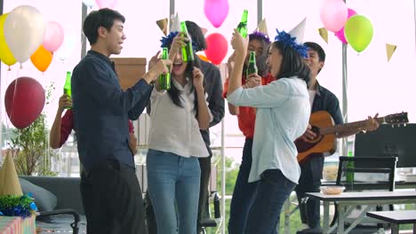 Team-of-young-people-dancing-and-having-fun-celebrate-with-toast-and-clinking-raising-glasses-in-their-office.-Slow-motion-shot