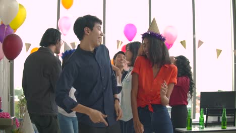 Team-of-young-people-dancing-and-having-fun-celebrate-with-toast-and-clinking-raising-glasses-in-their-office.-Slow-motion-shot