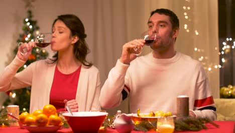 glückliches-Paar-trinken-Rotwein-am-Weihnachtsessen