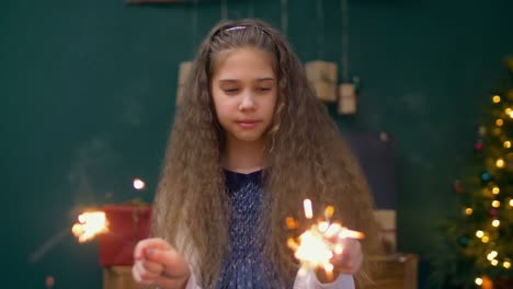 Alegre-niña-jugando-con-las-luces-de-Bengala-en-Navidad