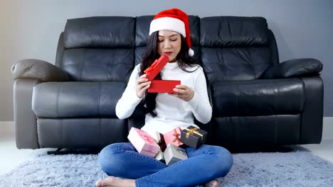 glückliche-Frau-mit-Weihnachtsgeschenk-im-Wohnzimmer