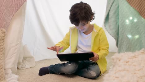 little-boy-with-tablet-pc-in-kids-tent-at-homea