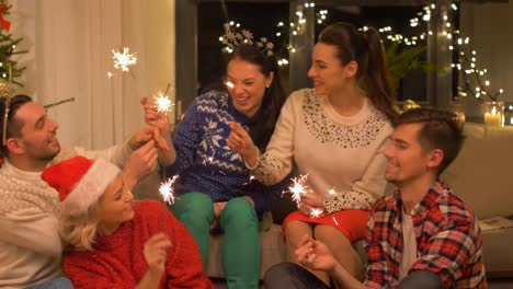 Glückliche-Freunde-mit-Wunderkerzen-feiert-Weihnachten-zu-Hause-feiern