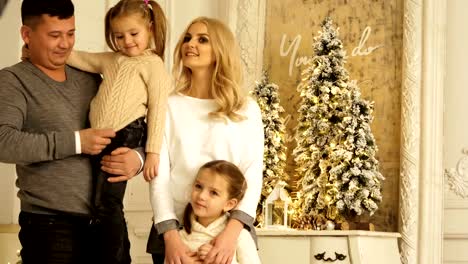 Portrait-of-happy-parents-with-two-daughters-posing.-Christmas-photo-session