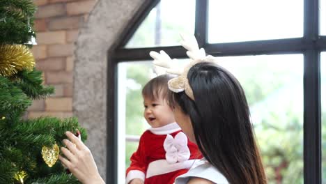 Tochter-von-Mutter-und-Kind-schmücken-den-Weihnachtsbaum-im-Innenbereich.-Closeup-Zeitlupe-Porträt-des-liebenden-Familie,-Frohe-Weihnachten-und-schöne-Feiertage!