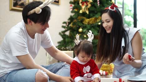 Familia-feliz-de-hija-de-padre-y-el-bebé-de-madre-con-árbol-de-Navidad-en-casa.-¡Closeup-retrato-de-cámara-lenta-de-amorosa-familia,-feliz-Navidad-y-felices-fiestas!