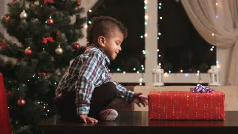 Boy-unwrapping-gift-on-table.