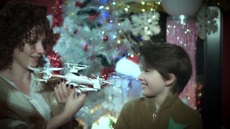 4k-Christmas-and-New-Year-Holiday-Child-Showing-his-Present-Drone-to-Mom