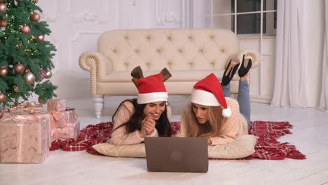 Two-happy-lady-with-pc-in-flat-christmas