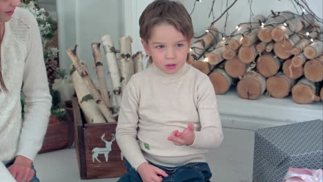 Young-mother-helping-her-little-boy-counting-on-his-fingers-on-Christmas-eve