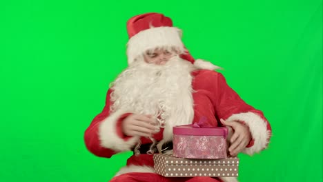 Santa-Claus-holding-a-gift-in-his-hand-on-a-Green-Screen-Chrome-Key