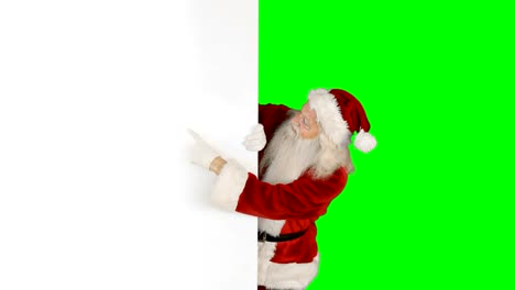 Santa-claus-hiding-behind-green-screen