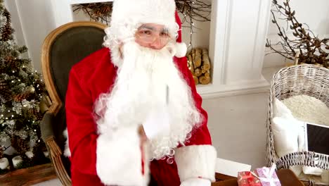 Santa-Claus-finishing-writing-and-checking-his-letter-to-a-kid