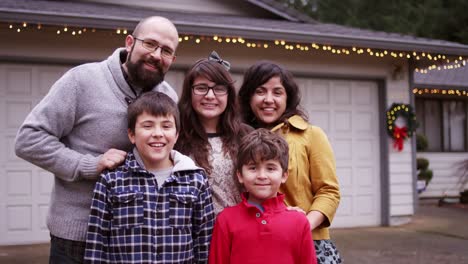 Retrato-de-un-mestizaje-familiar-de-pie-delante-de-su-casa-con-luces-de-Navidad