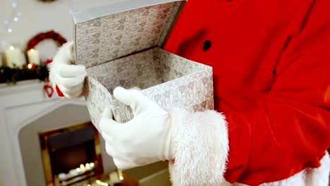 Mid-section-of-santa-claus-holding-gift-box