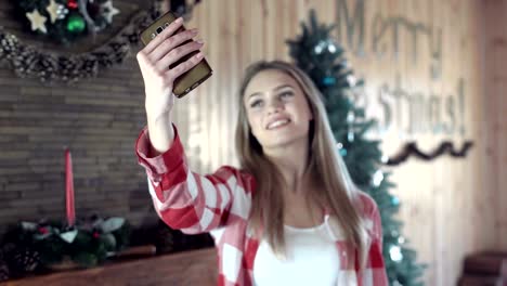 Woman-taking-selfie-in-front-of-Christmas-tree