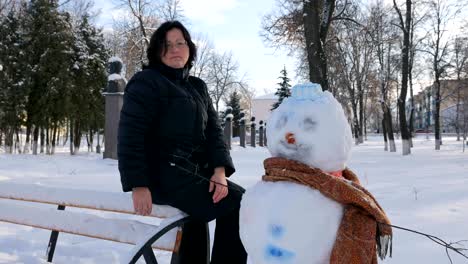 Young-Woman-Building-Snowman-in-the-Park.-In-the-winter
