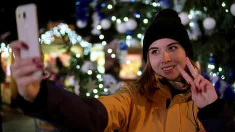 Junge-Frau,-die-Aufnahme-von-Fotos-mit-Handy-auf-Weihnachtsmarkt