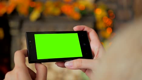 Woman-looking-at-smartphone-with-green-screen